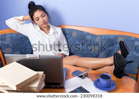 Young woman resting with legs on desk