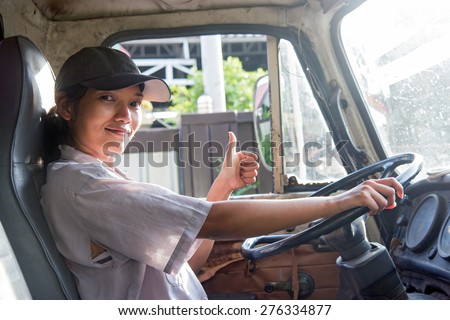 young woman driving a truck with thumb up