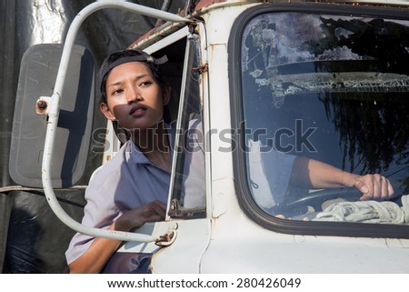 woman truck driver in the truck looking out from window