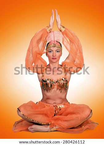 Woman in oriental costume sitting in yoga position