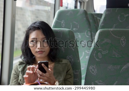 Woman with mobile phone in the empty bus