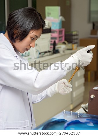 female technician collect specimen with auto pipette in hospital laboratory