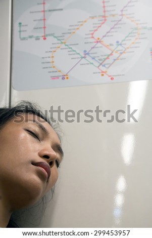 woman sleeping on the train under the map of public transport