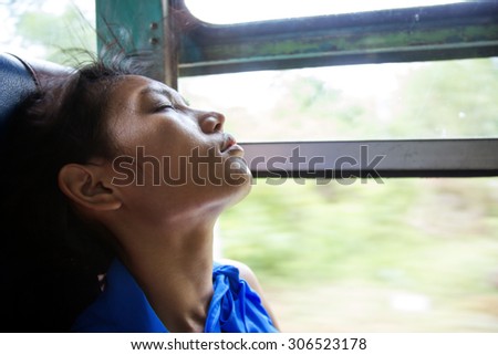 Portrait of a woman sleeping in a moving bus near the window