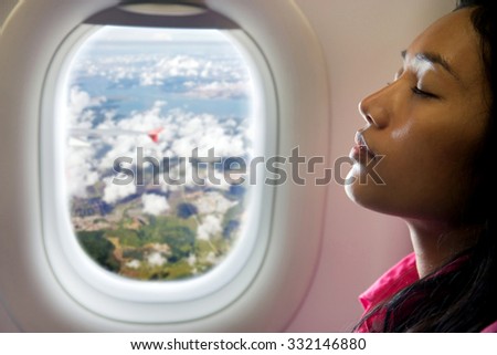 young beautiful woman resting on airplane beside window