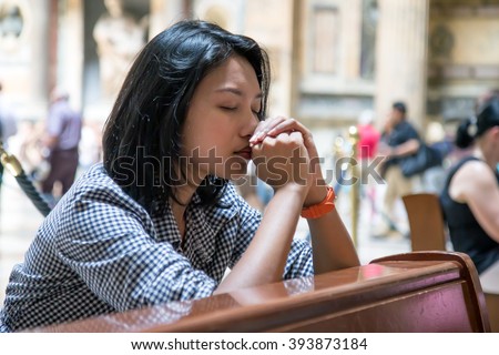 Woman praying in the church. Believers meditates in the Church. Peaceful people praying in church. Spiritual time of prayer.