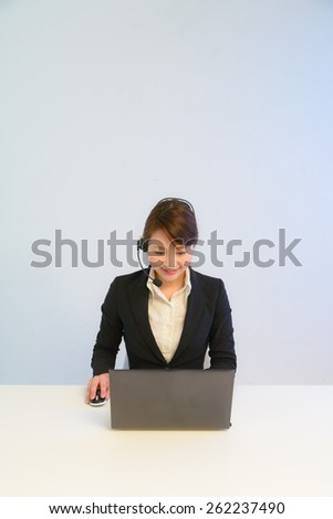 Female customer support operator looking at PC