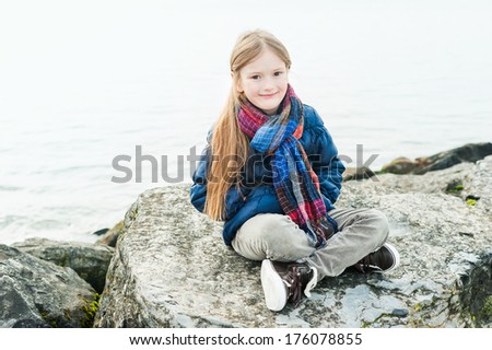 Outdoor portrait of a cute little girl next to lake on a nice day