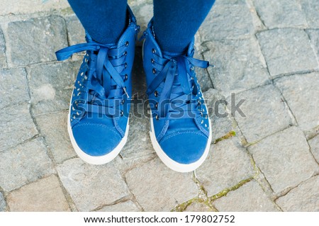Blue tennis shoes on a stone background