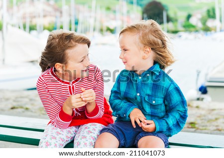 Outdoor portrait of adorable children on a very windy day