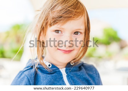Outdoor portrait of a cute little girl with freckles