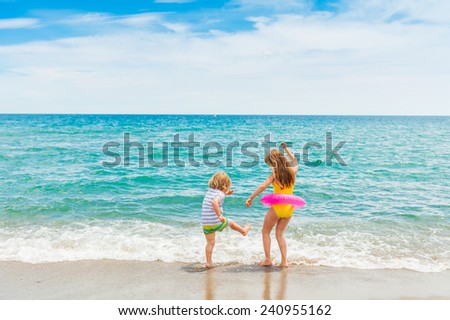 Two kids having fun on summer vacation, playing in the sea