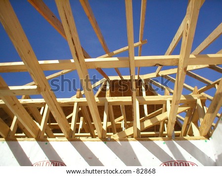 House under new construction showing roof and ceiling beams.