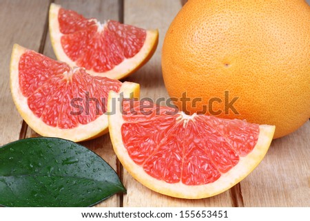 Sliced red grapefruit on a wooden background