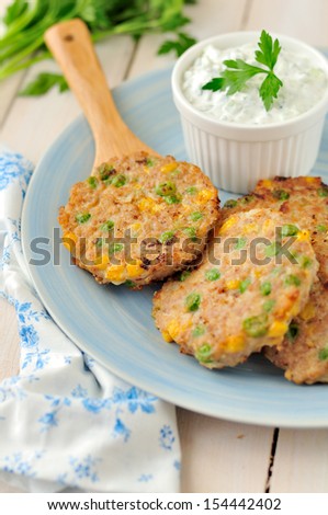 Corn, pea and turkey patties with cucumber, cilantro / parsley and sour cream dressing, copy space for your text