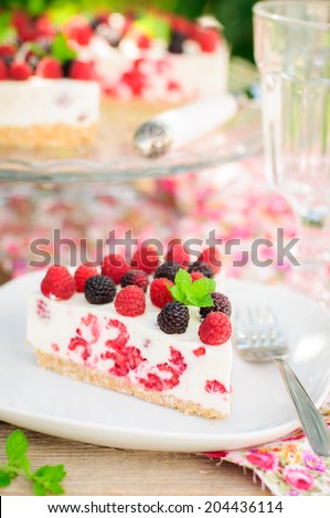 A Piece of No-bake Fresh Raspberry Cheesecake with Red and Black Raspberries and Melissa, Summer Cake, copy space for your text