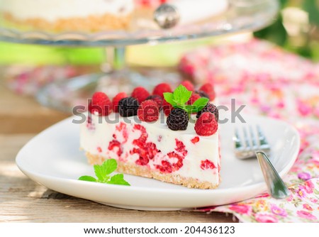 A Piece of No-bake Fresh Raspberry Cheesecake with Red and Black Raspberries and Melissa, Summer Cake