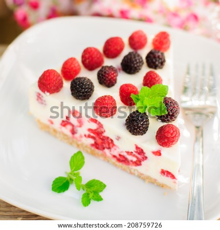 A Piece of No-bake Fresh Raspberry Cheesecake with Red and Black Raspberries and Melissa, Summer Cake, close up, square