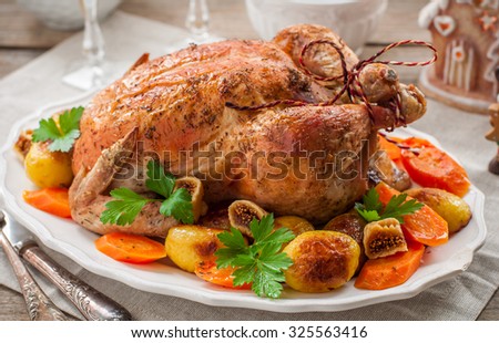 Christmas Stuffed  Chicken Served with Potatoes, Carrots and Figs on a Wooden Table
