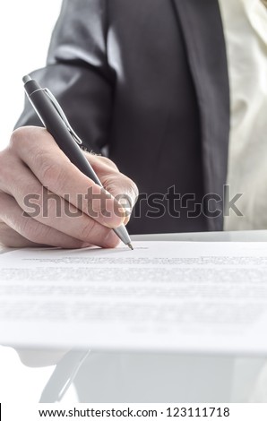 Closeup of a businessman\'s hand signing a contract on a white desk with reflection.