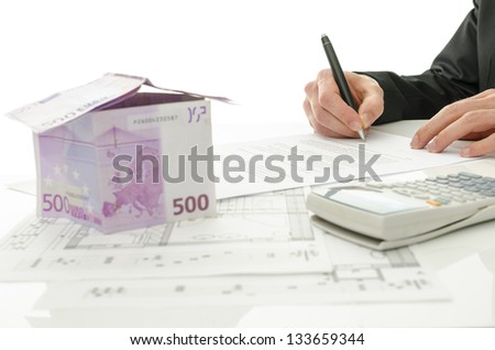 Signing contract of house sale with house made of 500 Euro money and  architectural building plan on a white table.