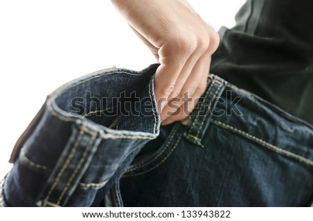 Detail of woman skinny waist in too large old jeans. Concept of successful dieting. Shallow dof.