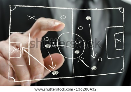 Closeup of coach pointing to a football strategy plan drawn on a virtual screen.
