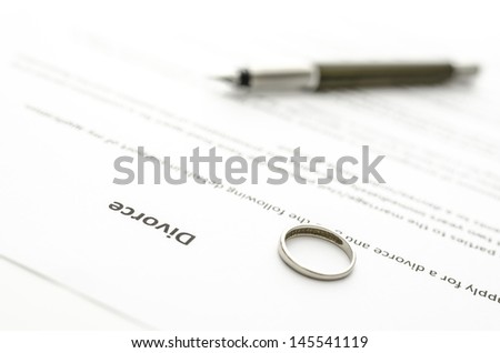 Wedding ring lying on divorce decree.