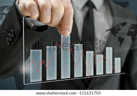 Business man hand pulling upwards column of interactive business graph.