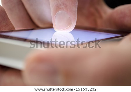 Close up of a man using touch screen device.