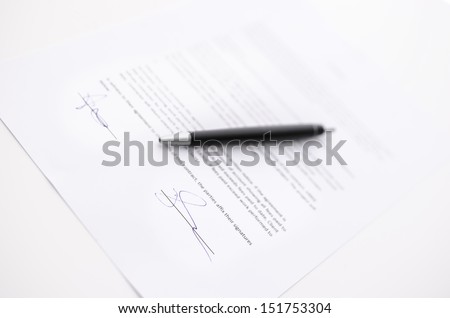 Business contract and a pen. Focus on a signature.