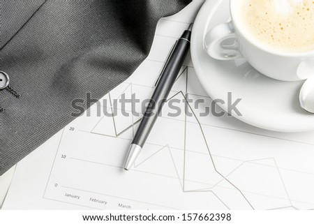 Top view of annual financial business report with coffee and pen on it.