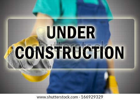 Closeup of construction worker pressing Under construction button on virtual screen.