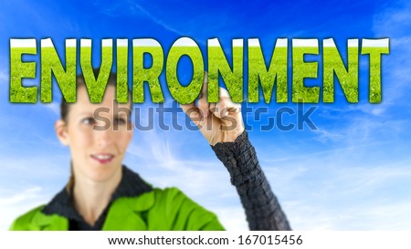 Young female environmental activist writing word Environment on virtual screen.