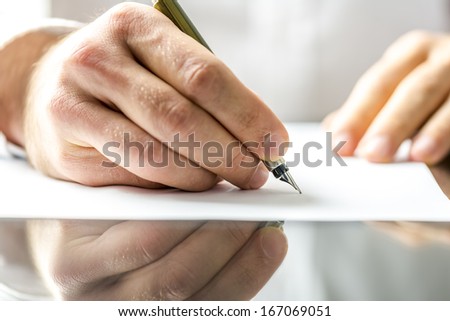 Man writing on a blank paper with ink pen.