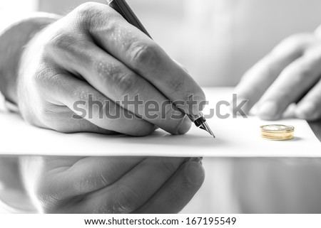 Closeup Of Male Hand Signing Divorce Papers.