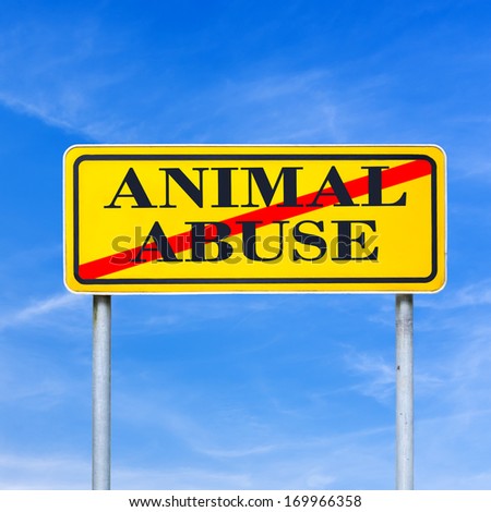 Conceptual image of a bright yellow traffic sign against a blue sky with the words - animal abuse - crossed through depicting stopping harm to animals in laboratories and at the hands of people