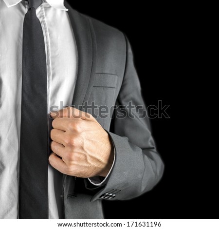 Conceptual image of a stylish businessman, executive or professional holding the lapel of his jacket conceptual of success, confidence, expertise and authority