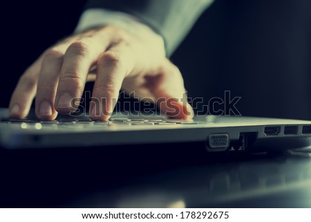 Closeup of the hands of a man typing on a computer. With retro filter effect.