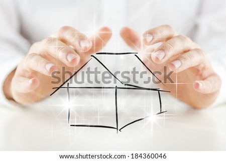 Man protecting a hand-drawn black and white sketch of a house with his hands with a multiple bright shining star effect in a conceptual image.