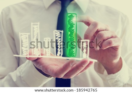 Retro image of businessman holding a hand-drawn bar graph in his hand with a single elevated green bar which he is touching and activating with his finger as though on a virtual computer interface.