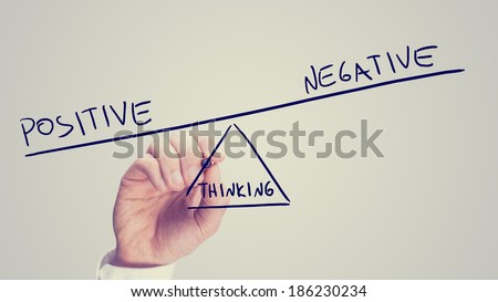 Man drawing a seesaw showing an imbalance between Positive - Negative - Thinking with the word positive being weighted more than the word negative on opposites ends with Thinking as the fulcrum.