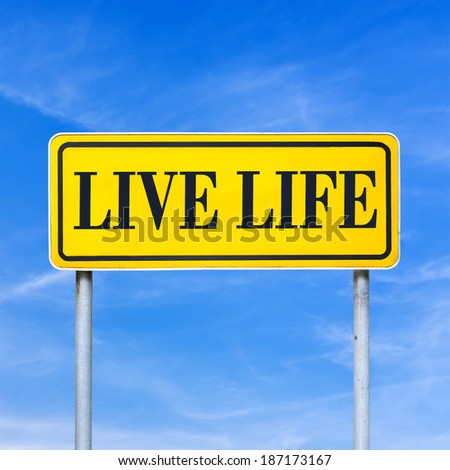 Live life written on yellow roadsign over blue sky.