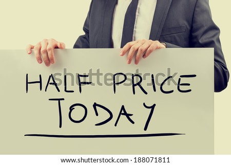 Retro vintage or instagram style image of a businessman holding white board with special offer of the day: Half price today.