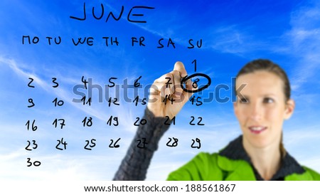 Woman ringing the date of June 8th as a reminder for celebrating World Oceans Day to commemorate to oceans, marine life, seafood and products of the world on a hand-drawn calendar on a virtual screen.