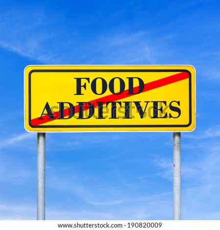 Food additives prohibited - conceptual image with the words Food additives crossed through in red on a yellow traffic sign against a sunny clear blue sky.