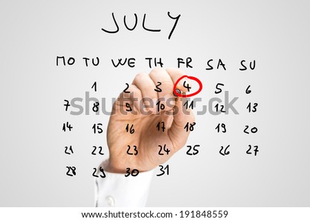 Male hand marking 4th of July - Independence day in the United States - on a virtual calendar.
