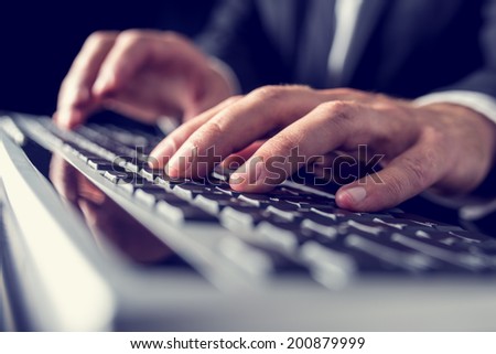 Retro vintage or instagram style image of a businessman typing on computer keyboard.