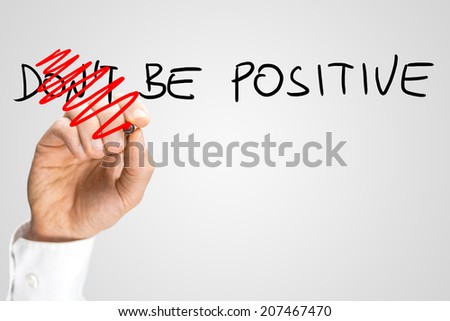 Concept of positivity and optimism - male hand changing a Don\'t be positive into a Be positive sign.