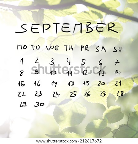 Hand-drawn calendar for the month of September over a faded spring background with flare effect of fresh green beech tree leaves on a branch.